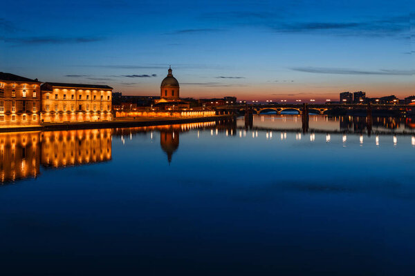 French ancient town Toulouse and Garonne river panoramic night view. Toulouse is the capital of Haute Garonne department and Occitanie region, France, South Europe. Famous tourist destionation.