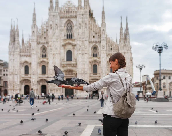 여행하는 여성은 이탈리아 밀라노의 대성당인 두오모 리아노 근처에서 비둘기를 먹는다 로열티 프리 스톡 이미지