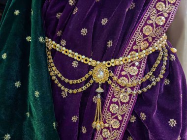 Geleneksel bir sari giyen ve göbek zinciri takan bir kadın. Moda mağazası olarak da bilinir.