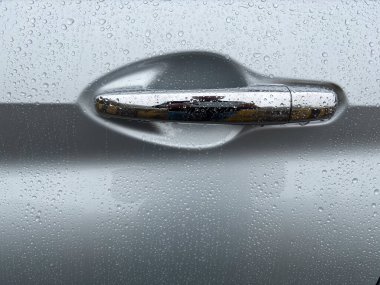 Gümüş araba kapı kolu ve yağmur damlaları yakın plan