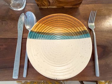 Boş kaşık çatalı ve bıçak tahta bir masanın üstünde.