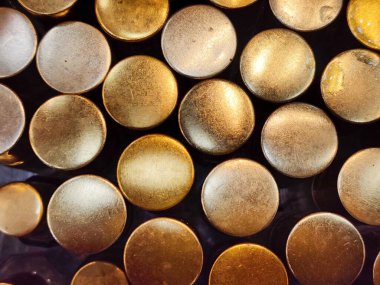 Değişen altın ve kahverengi tonlarına sahip dairesel metal dokuların soyut arkaplanı.