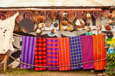 Kenya 'da renkli battaniye sergisi satılıyor. Ekranda kırmızı, mavi ve yeşil de dahil olmak üzere çeşitli renk ve desenler yer alıyor. Sıcaklık ve rahatlık kavramı