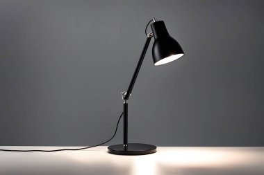 Masanın üzerinde siyah bir lamba oturuyor. Işık yanıyor ve lamba yanıyor.