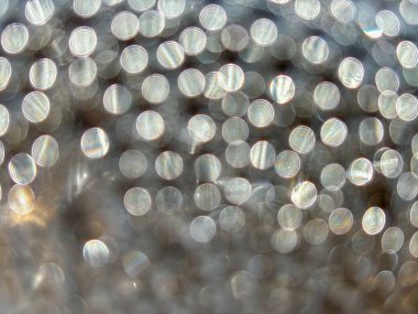 Pek çok küçük dairenin bulanık bir görüntüsü. Daireler farklı boyutlarda ve renklerde. Bu görüntünün hayali, ruhani bir kalitesi var.