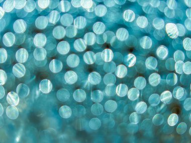 Pek çok küçük dairenin bulanık bir görüntüsü. Daireler farklı boyutlarda ve renklerde. Bu görüntünün hayali, ruhani bir kalitesi var.