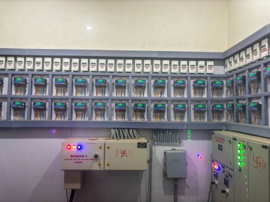 Sol üst tarafında yeşil ışık olan elektrik kutularından oluşan bir duvar. Kutular 1 'den 15' e kadar numaralanmış.