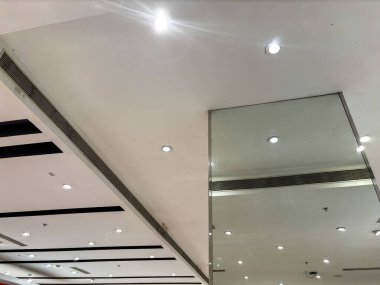 Tavan beyaz ve birkaç ışığı var. Oda çok aydınlık ve temiz ve aynalı..