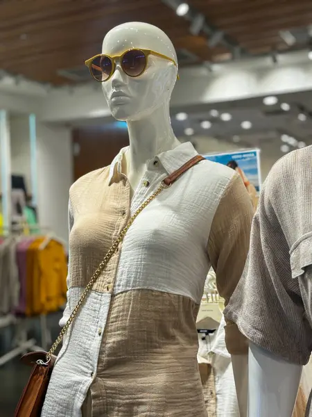 A mannequin wearing a dress and goggles.. The mannequin is standing in a store