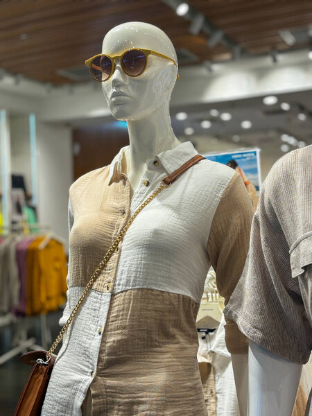 A mannequin wearing a dress and goggles.. The mannequin is standing in a store