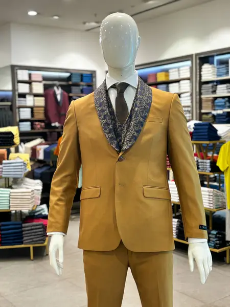 A mannequin wearing a brown colored suit.. The mannequin is standing in a store