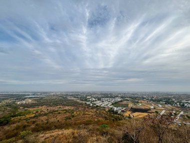 Arkasında dağ olan bir şehir, Ralamandal, Indore, Hindistan. Gökyüzü bulutlu ve şehir çoğunlukla beyaz.