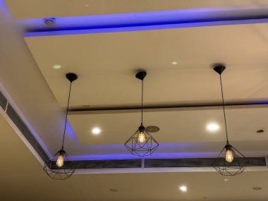 Tavan mavi ve üzerinde ışıklar asılı. Işıklar tavandan eşit aralıklarla sarkıyor.