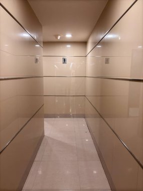 Beyaz duvarları ve bir sıra pisuarı olan uzun bir koridor. Pisuarların hepsi boş.