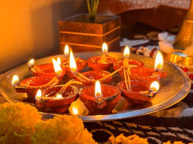 Üzerinde çiçek deseni olan bir tabak mum. Mumlar yakılır ve daire şeklinde dizilir.