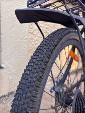 Siyah lastik ve turuncu yansıtıcısı olan siyah bir bisiklet. Lastik siyah ve lastik izi var.