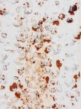 Görüntü, pek çok küçük kahverengi benekli paslı bir metal yüzeye ait. Yüzey eski ve yıpranmış görünüyor. Çürüme ve terk edilme hissi var. Kahverengi noktalar paslanmanın sonucu gibi görünüyor.