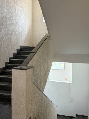 Üstünde pencere olan bir merdiven. Pencere açık ve merdivenler karanlık. Merdiven boş.