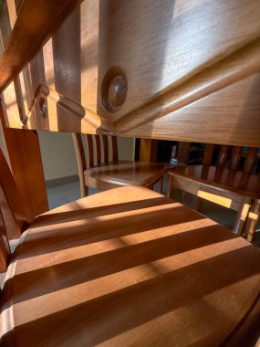 Etrafında üç sandalye olan ahşap bir yemek masası. Sandalyeler bir şekilde masa tarafından kısmen gizleniyor, derinlik ve boyut hissi yaratıyor.