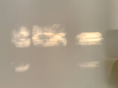 Beyaz bir duvarda bir kişinin bulanık bir yansıması görülüyor. Yansıması sakallı ve bıyıklı birine benziyor. Bu görüntünün hayali, ruhani bir kalitesi var.