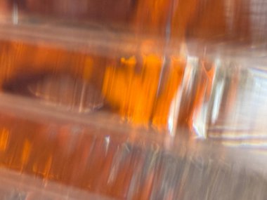 Sarı renkli bir arabanın farının bulanık bir görüntüsü. Görüntünün sıcak ve parlak bir kalitesi var ve sarı renk ona derinlik ve boyut hissi veriyor.