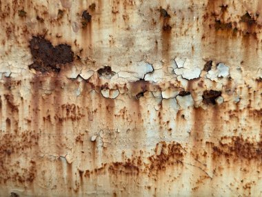 Bir sürü çatlağı ve deliği olan paslı bir metal yüzey. Yüzey eski ve yıpranmış.