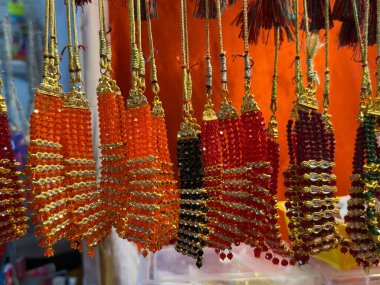 Altın aksanlı renkli boncuklar ve boncuklar. Boncuklar çeşitli renk ve boyutlarda düzenlenerek canlı ve göz alıcı bir görüntü elde ediliyor.