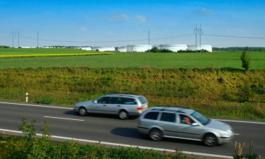 Tarlalarda ve çayırlarda kimyasal tankları olan bir arka plan. Bahar endüstrisi, doğadaki endüstri, trafik yolu, çevre,
