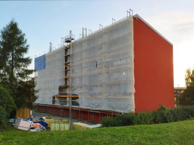 Paneldeki evin yeniden canlandırılması. İskelesi olan eski prefabrik bir bina, dış görünüş yalıtımı, balkonların parlatılması. Avrupa şehrinde inşaat alanı.