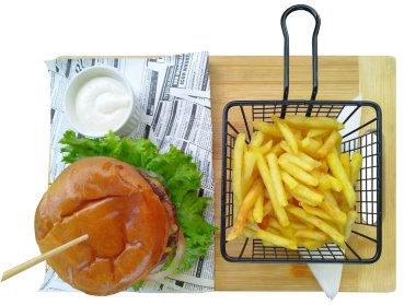 Hamburger ve garnitürlü patates kızartması. Tel bir sepetin içinde patates kızartması, hamburger, tepside sos ve ahşap tahta..