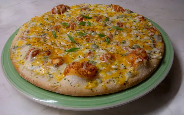 Background with baked cheese pizza. Cheese - vegetable pizza for vegetarians on a green plate.