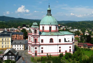 Egemen bir manastır ile ağaçlandırılmış dağ manzarası. Çek Cumhuriyeti 'nin Jablonne kentindeki Dominik Manastırı, Podjestedi' deki Basilica ve Pojestedi 'deki Ore Dağları' na (Krusne Hory) bakan dağ panoramik manzarası.