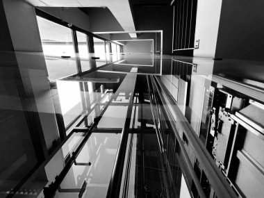 Lift shaft. Glass elevator in the building, monochrome. Construction glazed internal elevator to the sky, urban architecture. Background. clipart