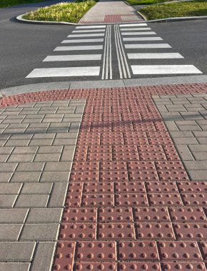 Sokakta yürürken. İşaretli engelsiz geçiş. Engelli yayalar için işaretli kaldırım ve yol kenarları.