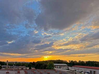 Manzaralı güzel bir gün batımı. Akşamın erken saatlerinde, Prag şehir panoraması ile ufukta, ormanın içinden ve iş yerindeki taşıma araçlarının olduğu yer..