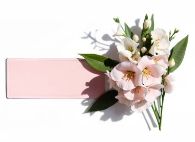 Aşk kartı, pembe buketli çerçeve. Metnin için boş pembe etiket, beyaz-pembe zambak çiçekleri ile, izole nesne.