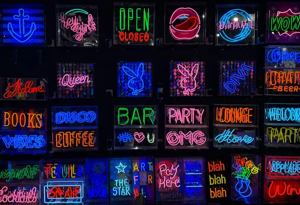 Siyah duvar arkaplanındaki renkli neon işaretleri koleksiyonu.