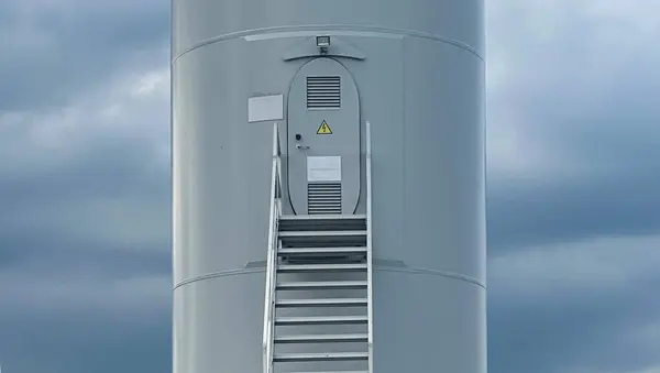 Giriş merdivenleri ve servis kapısı olan rüzgar türbini kulesi.