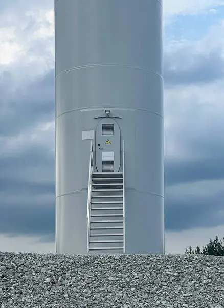 Giriş merdivenleri ve servis kapısı olan rüzgar türbini kulesi.