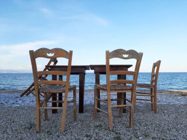 Yunanistan 'ın Rodos kentinde Ege Denizi önündeki masa ve sandalyeler.