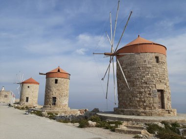 Yunanistan 'ın Rodos kentinde yel değirmenleri ve Aziz Niklas kalesi.