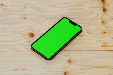 Boş ekran akıllı telefon dizüstü bilgisayarlı ve ahşap çalışma masasında aksesuarlı, 3D görüntüleme.