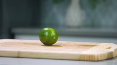 Şef limonlu meyveyi yavaş çekimde kesti, şef limonu kesti, limonu yakın çekimde dilimledi.