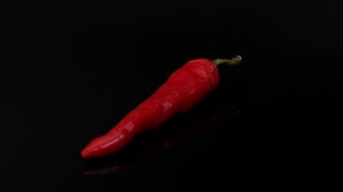 Siyah arka planda kırmızı biber, siyah biberde kırmızı biber, yakın planda kırmızı biber.