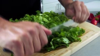 Şef salatayı yavaş çekimde keser, şef salata yapar, salatayı yakın çekimde keser.