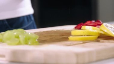 Kız limonu yavaş çekimde kesti, şef portakalı kesti, limonu yakın çekimde dilimledi.