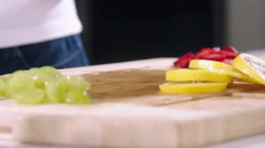 Kız limonu yavaş çekimde kesti, şef portakalı kesti, limonu yakın çekimde dilimledi.