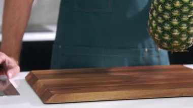 Şef ananası yavaş çekimde keser, şef ananası yakın çekimde doğrar.