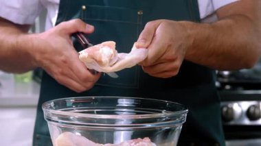 Şef makasla kesiyor tavuk kanatlarıyla kesiyor, yakın plan chiken kesiyor ızgarada tavuk doğruyor, kasede Hicken kesiyor.