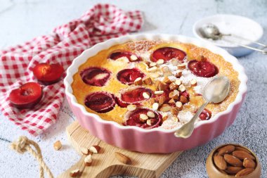 Bademli kırmızı erik clafoutis (turta), krema sosu, Fransız mutfağı. 